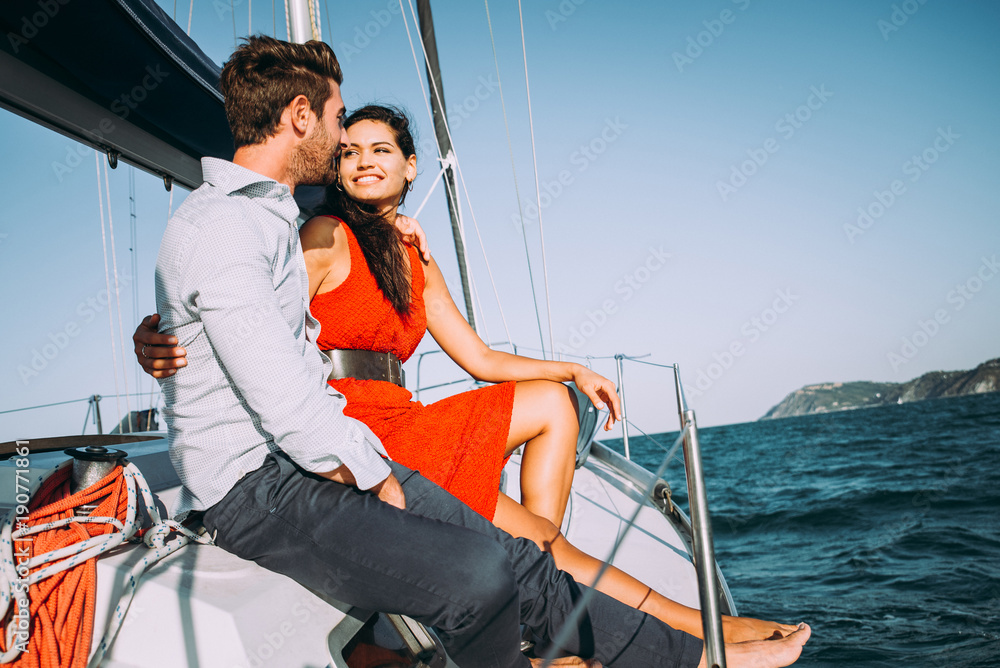 happy couple taking a romantic cruise on the sail boat happy couple taking a romantic cruise on the sail boat