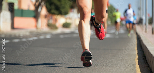 Marathon running in the light of evening,running on city road detail on legs