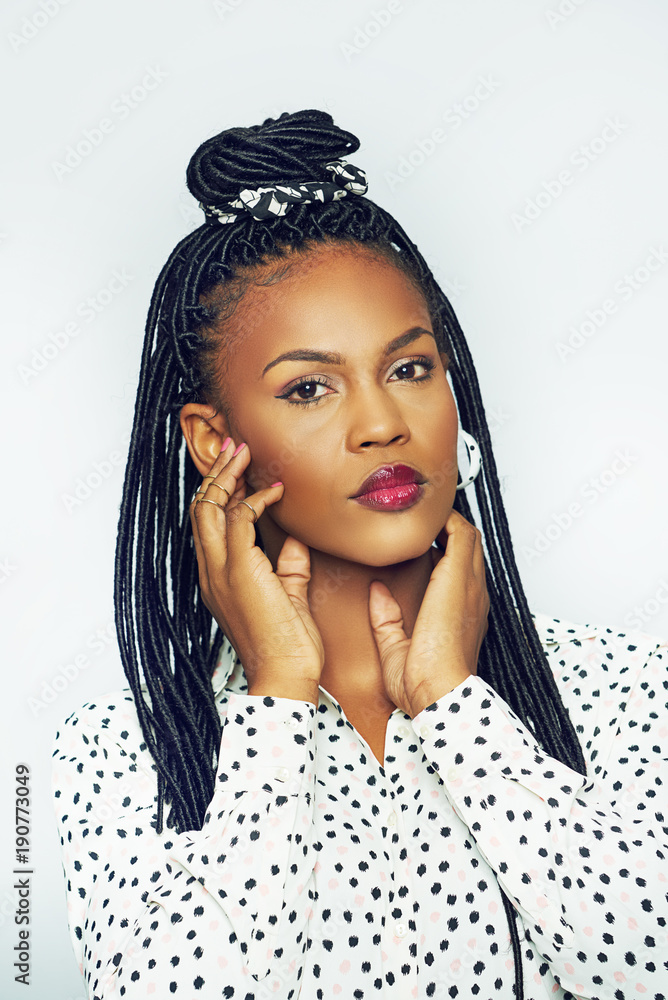 Young black woman touching face and looking at camera Young black woman touching face and looking at camera