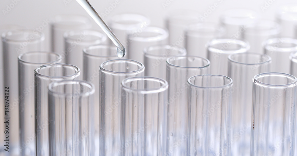 Pipette adding fluid to one of several test tubes Pipette adding fluid to one of several test tubes