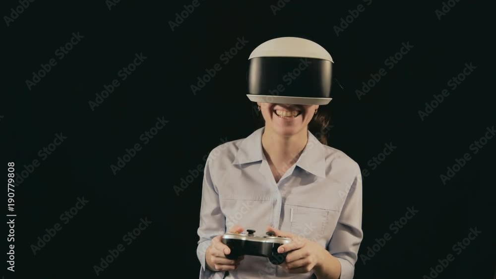 Girl in VR glasses of virtual reality with gamepad playing game. virtual augmented reality helmet. Future technology concept. Testing the application in virtual reality. Smartphone with VR headset. Girl in VR glasses of virtual reality with gamepad playing game. virtual augmented reality helmet. Future technology concept. Testing the application in virtual reality. Smartphone with VR headset.