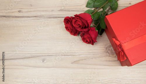 Red roses and gift box on wooden table, valentines Day, wedding day concept