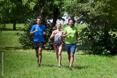 Woman and two young men run...