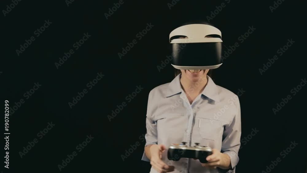 Girl in VR glasses of virtual reality with gamepad playing game. virtual augmented reality helmet. Future technology concept. Testing the application in virtual reality. Smartphone with VR headset. Girl in VR glasses of virtual reality with gamepad playing game. virtual augmented reality helmet. Future technology concept. Testing the application in virtual reality. Smartphone with VR headset.