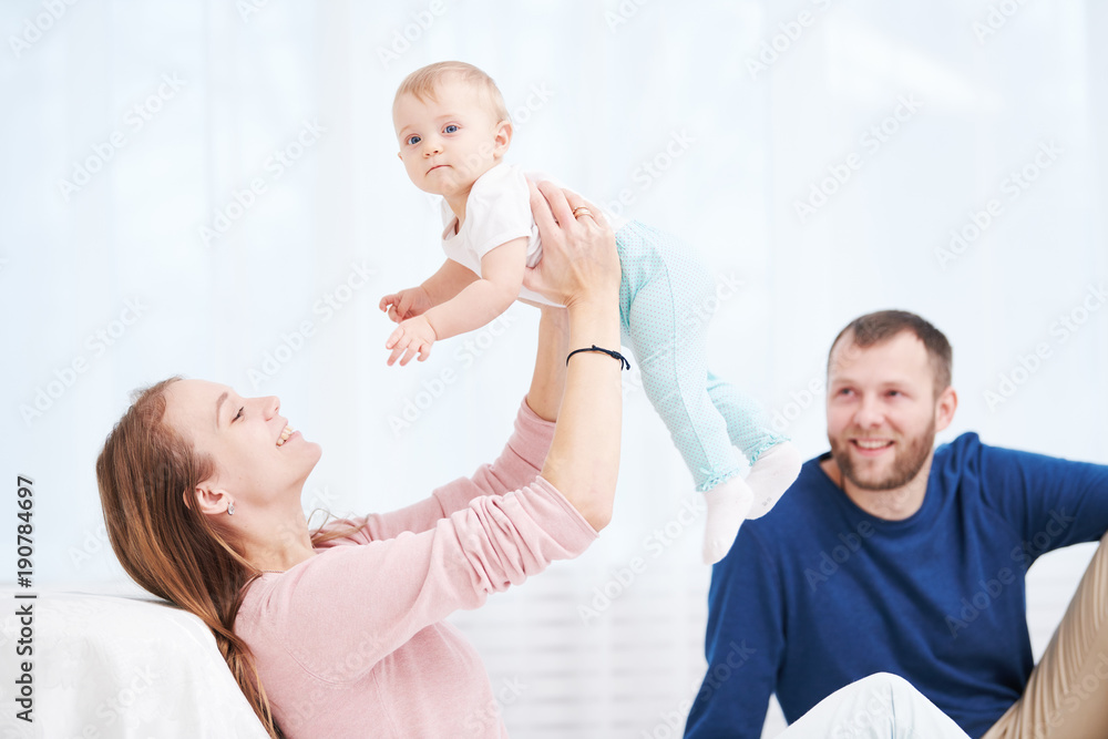 Parenting family. Mother and father playing with little newborn baby