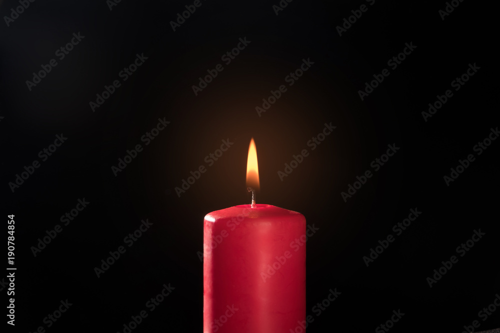 burning red candle on a black background burning red candle on a black background