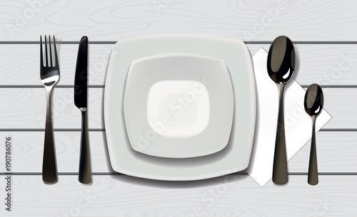 Empty realistic plate with spoon, knife and fork on a wooden background. Cutlery on a wood table