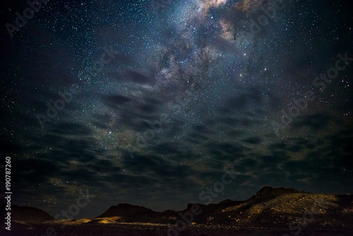 Milky Way arch, stars in the sky, the Namib desert in Namibia, Africa. Some scenic clouds.