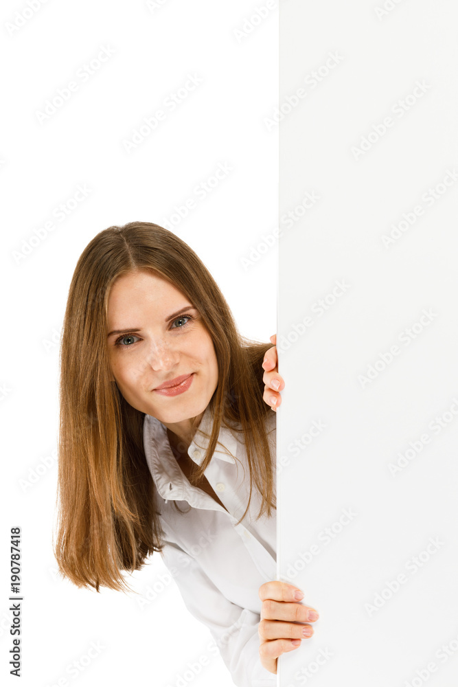 Young attractive girl peeking behind blank board on white background Young attractive girl peeking behind blank board on white background