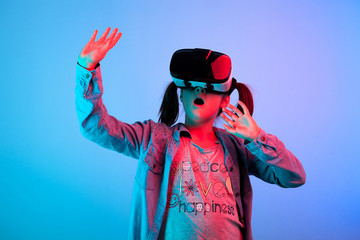 Amazed young girl experiencing virtual reality with a VR headset on the head