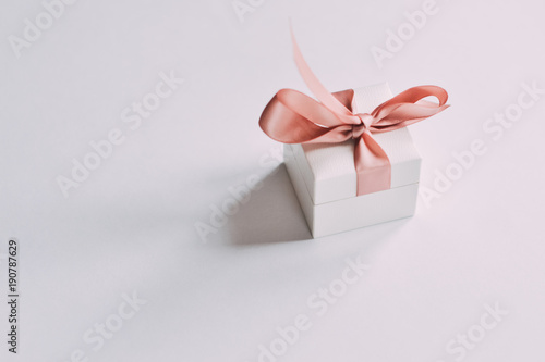Close up shot a small gift wrapped with pink ribbon