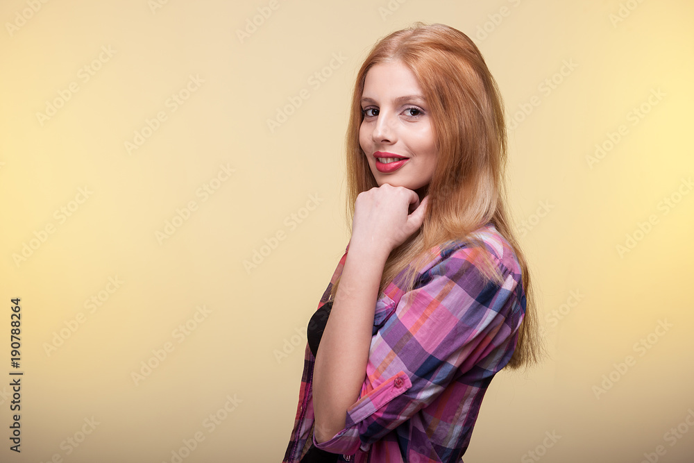 Blonde girl smiling and looking at the camera on yellow background Blonde girl smiling and looking at the camera on yellow background