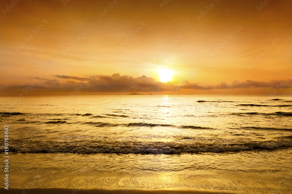 Obraz premium Sunset in the twilight time with sky yellow and orange color over the sea slowly waves at the tropical beach.