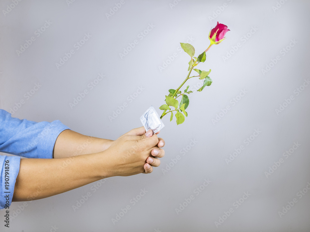 Men are holding roses for love and holding condoms in their hands, condescending love, Valentines Day.