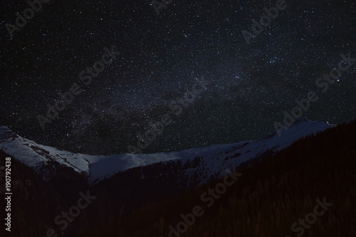 Mountain peaks in the background of the milky way. Night landscape with starry sky