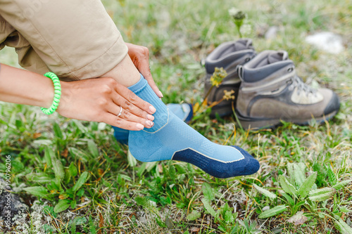 woman puts on high-tech trekking socks for hikes