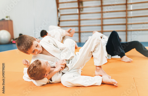 Chłopcy w mundurach ćwiczą sztukę walki