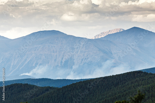 Distant smoke of wildfire in mountains photo
