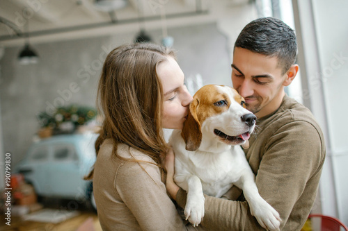 Young caucasian couple with beagle in dining room