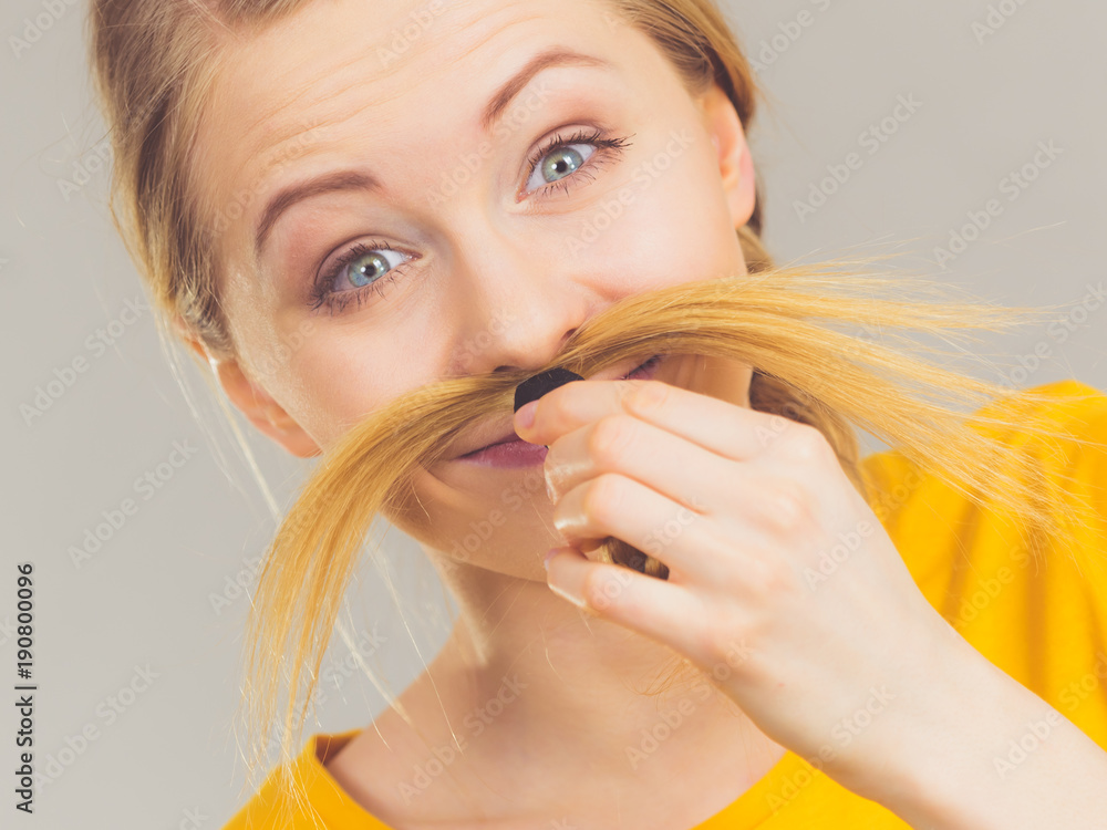 Woman making moustache out of blonde hair Woman making moustache out of blonde hair