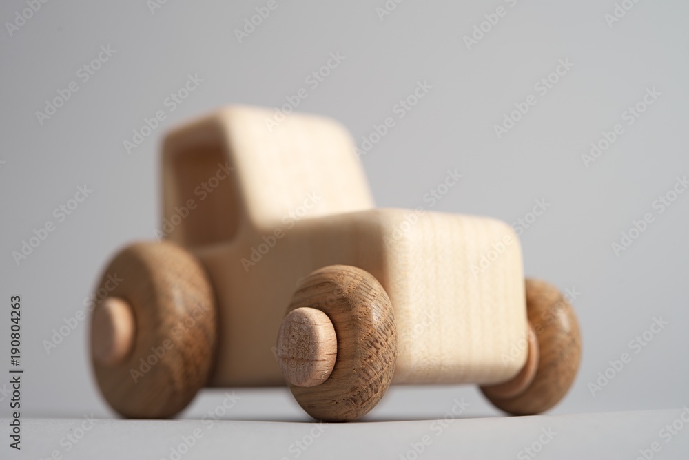 Wooden toy tractor on light isolated background