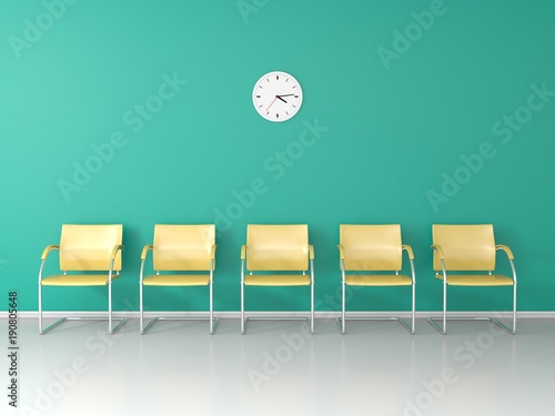 Yellow chairs in the waiting room with wallclock on green wall photo