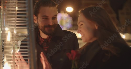 Young beautiful couple on night date in a city. Young couple in love warming by the outdoor fireplace. photo