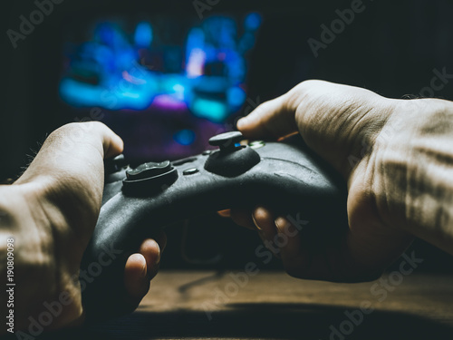 video game controller joystick in the hands playing on a tv photo