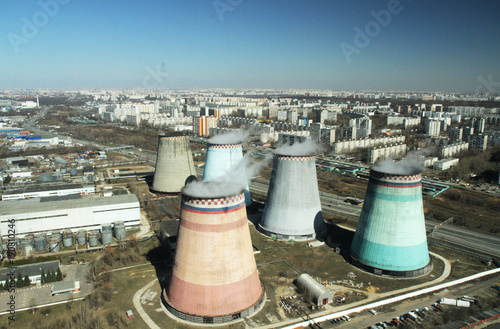 Cooling pipes are several nearby in the city. Photo of a cooling tower in a megacity with a close-up view
