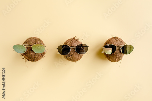 Coconuts in sunglasses on yellow background. The apartment lay, top view © K.Decor