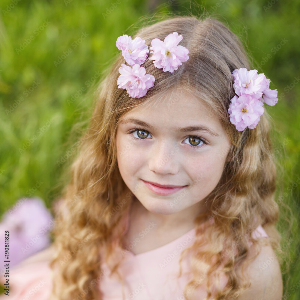 Pretty little girl in blossom cherry garden on beautiful spring day Pretty little girl in blossom cherry garden on beautiful spring day
