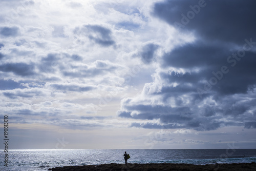 lonely surfer looking at the ocean waiting waves