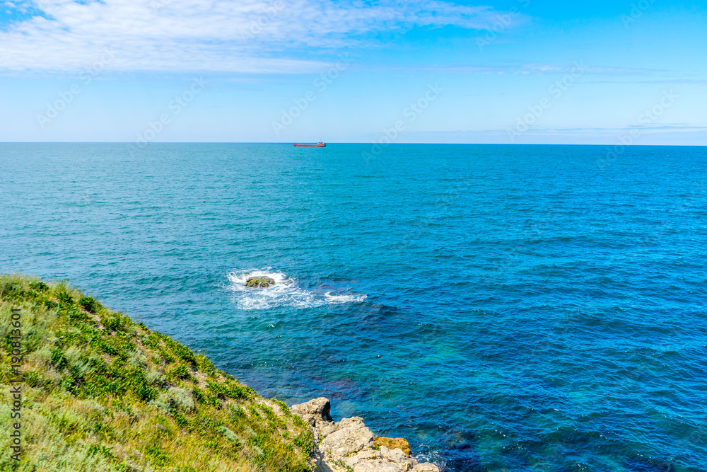 The coast of the Black Sea and the ship far away in summer in Sevastopol, Crimea, in Russia