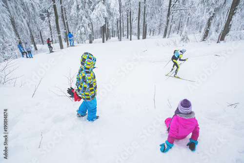 Young fans on professional nordic ski race in white nature