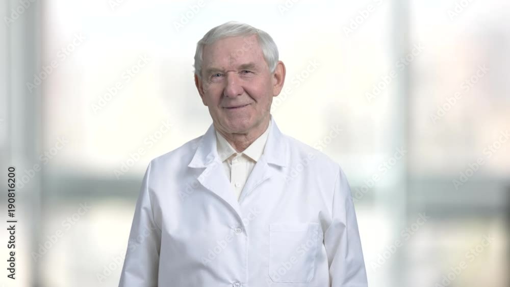 Old grandpa in white shirt and coat smiling. Portrait of senior man in abstract blurred bright background. Old grandpa in white shirt and coat smiling. Portrait of senior man in abstract blurred bright background.