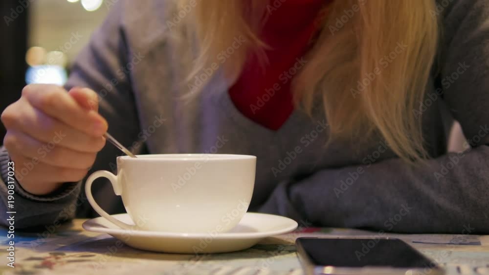 4k Pretty Blondie girl drinks tea from white cup and take spoon in cafe close-up 4k Pretty Blondie girl drinks tea from white cup and take spoon in cafe close-up