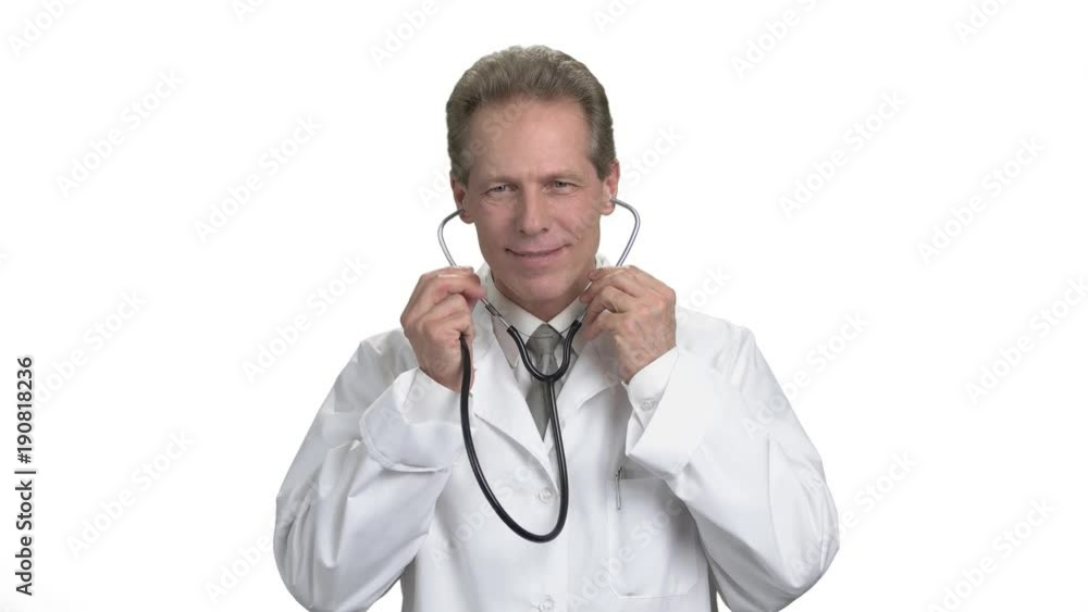 Put on stetoschope on head, insert into ears. Portrait of mature adult handsome doctor in medical suit, white isolated background. Put on stetoschope on head, insert into ears. Portrait of mature adult handsome doctor in medical suit, white isolated background.