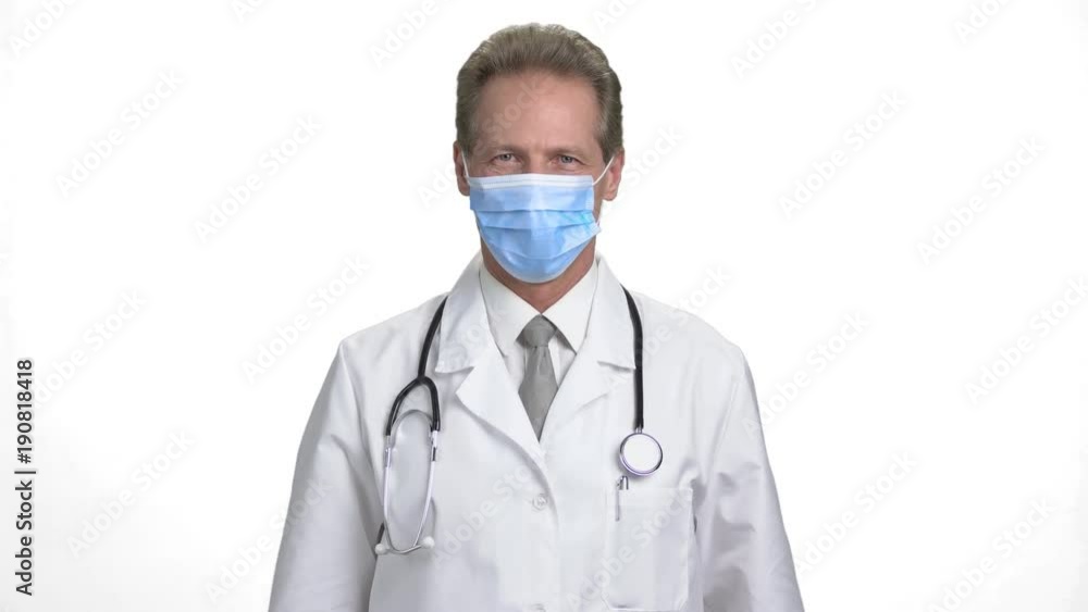 Doctor put on protection from germs. Portrait of mature physician man in white isolated background. Doctor put on protection from germs. Portrait of mature physician man in white isolated background.