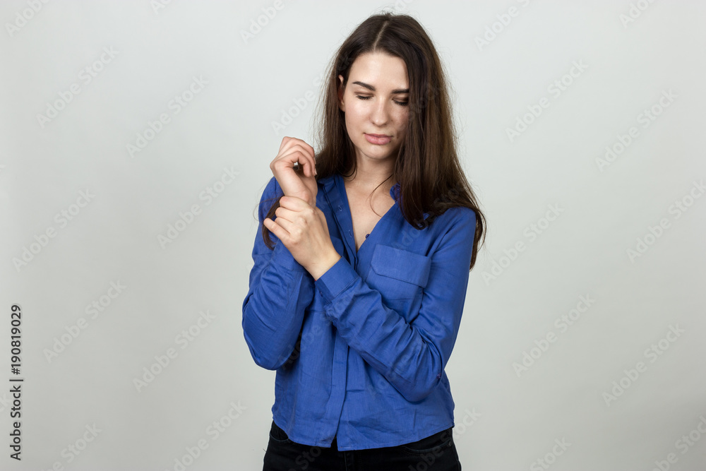 Woman holding sore wrist in her hand Woman holding sore wrist in her hand