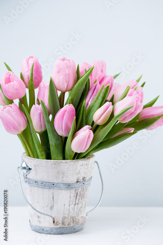 Fototapeta Naklejka Na Ścianę i Meble -  Spring easter tulips in bucket on white vintage background.