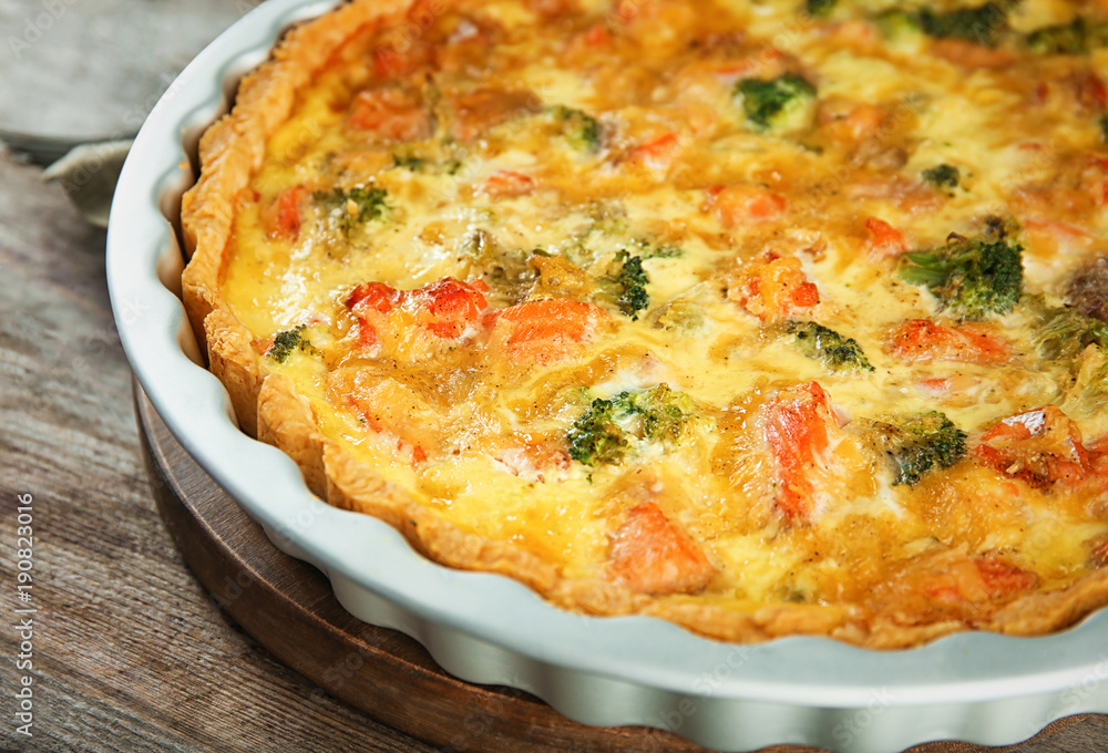 Baking dish with tasty broccoli quiche on table, closeup Baking dish with tasty broccoli quiche on table, closeup