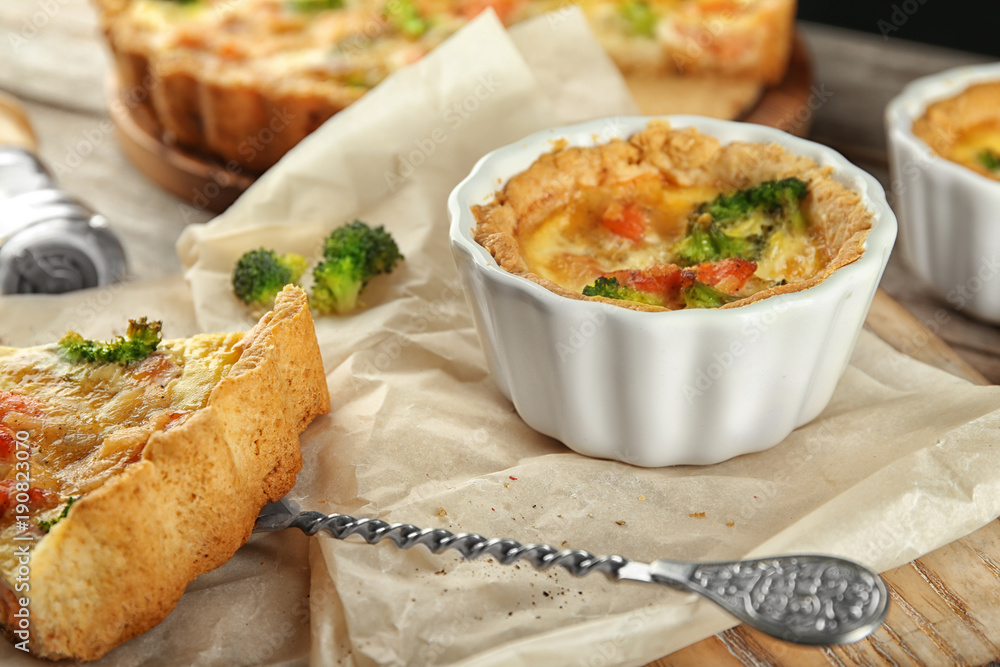 Ramekin with tasty broccoli quiche on table, closeup Ramekin with tasty broccoli quiche on table, closeup