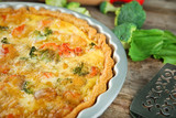 Baking dish with tasty broccoli quiche on table, closeup