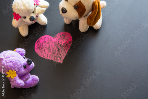 Soft plush toys around sketch of heart.