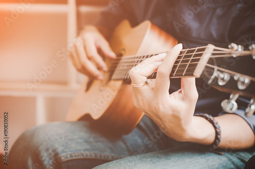 A handsome man playing acoustic guitar.Practicing in playing guitar.