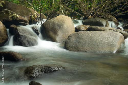 clodeup of waterfall movement on rock in forest photo