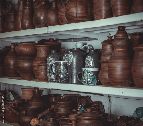 racks in a pottery workshop with pottery, many different pottery standing on the shelves in a potery workshop photo