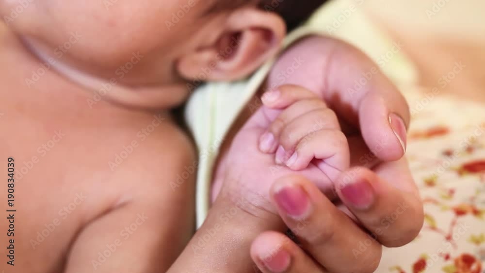 Newborn baby boy gripping mother's finger Newborn baby boy gripping mother's finger