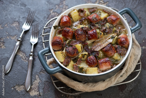 Bowl of Dublin coddle on a metal cooling rack or Irish dish of sausages, bacon, onions and potatoes, horizontal shot