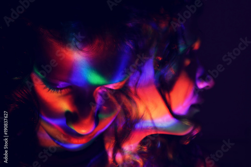 abstract portrait of young girl under colorful fluorescent Neon dark lights, enigmatic style.